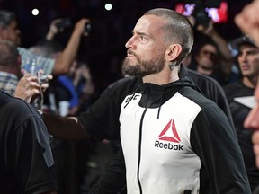 FILE - In this Sept. 10, 2016, file photo, CM Punk walks to the octagon before a welterweight bout at UFC 203 in Cleveland. Jurors have cleared former World Wrestling Entertainment champ CM Punk of defamation and invasion of privacy in a lawsuit brought by a wrestling doctor. Punk, whose real name is Phil Brooks, hugged his wife, former WWE star A.J. Lee., as the panel in Chicago delivered its verdict on Tuesday, June 5, 2018.