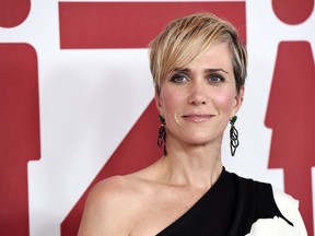 FILE - In this Dec. 18, 2017, file photo, Kristen Wiig, a cast member in "Downsizing," poses at a special screening of the film at the Regency Village Theatre in Los Angeles. Wiig does not look much like a villain in a photo released for "Wonder Woman 1984." Director Patty Jenkins on Wednesday, June 27, 2018, tweeted the first look at Wiig as Wonder Woman's foe, Cheetah. Wiig is dressed as Barbara Minerva, the mortal who morphs into a powerful nemesis.
