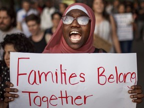 A woman shouts slogans during a rally against a banning travel from several Muslim-majority nations on Tuesday, June 26, 2018, in New York. Muslim individuals and groups, as well as other religious and civil rights organizations, expressed outrage and disappointment at the U.S. Supreme Court's decision Tuesday to uphold President Donald Trump's ban on travel from several mostly Muslim countries.