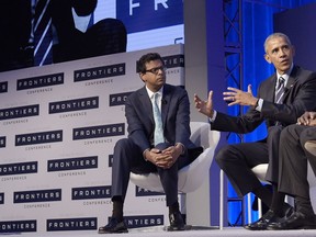 FILE- In this Oct. 13, 2016, file photo, Dr. Atul Gawande, left, listens as President Barack Obama speaks during a panel discussion at the White House Frontiers Conference at Carnegie Mellon University in Pittsburgh. Amazon, JPMorgan Chase and Berkshire Hathaway are turning to well-known author and Harvard professor Gawande to transform the health care they give their employees. The three corporate titans said Wednesday, June 20, 2018, that Gawande will lead an independent company that focuses on a mission they announced earlier this year: figure out ways to provide high-quality, affordable care.