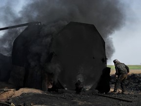 FILE - In this April 6, 2018 file photo, a former farmer works at a primitive refinery as he makes crude oil into diesel and other products, in Rmeilan, Hassakeh province, Syria. Ministers from the Organization of the Petroleum Exporting Countries and non-OPEC nations led by Russia meet in Vienna on Friday, June 22 and Saturday, June 23.