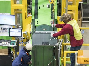 FILE- In this March 16, 2018, file photo, workers build washing machines on the assembly line at the Samsung washing machine facility in Newberry, S.C. On Friday, June 15, the Federal Reserve reports on U.S. industrial production for May.