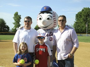 In this photo provided the Mets, Kendall and Nick Forde, front row, pose with their father John Forde, left, top row, Mr. Met, and former Mets pitcher Ron Darling, right top row, Saturday, June 2, 2018, at Shannon Forde Field, in Little Ferry, N.J. Darling was among those who attended the first softball games played at Shannon Forde Field, named for the New York public relations official who died of breast cancer in March 2016.  The field in Little Ferry, New Jersey, was dedicated a year ago and opened Saturday.