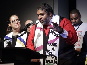 FILE - In this April 2, 2018 file photo,  Rev. Dr. William J. Barber II, center, and Rev. Dr. Liz Theoharis, left, co-chairs of the Poor People's Campaign, speak at the National Civil Rights Museum in Memphis, Tenn. They announced the campaign is preparing for 40 days of non-violent "direct action" in about 30 states that will climax with a rally in Washington this June. The organization is the rekindling of the campaign to help poor people that the Rev. Martin Luther King Jr. was working on when he was killed April 4, 1968, in Memphis.