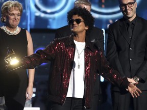 FILE - In this Jan. 28, 2018 file photo, Bruno Mars accepts the award for record of the year for "24K Magic" at the 60th annual Grammy Awards in New York. The Grammy Awards are extending the number of nominees in its top categories from five to eight.