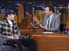 This image released by NBC shows comedian Pete Davidson, a cast member on "Saturday Night Live," left, with host Jimmy Fallon during a taping of "The Tonight Show Starring Jimmy Fallon," Wednesday, June 20, 2018, in New York where he confirmed that he is engaged to singer Ariana Grande.