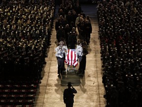 FILE - In this May 7, 2018, file photo, pallbearers walk alongside the casket of Cpl. Eugene Cole at the conclusion of the funeral service at the Cross Insurance Center in Bangor, Maine. John Williams, charged with killing Cole, told an investigator that the deputy tripped backward and was on the ground when he fired the shot that "eliminated" him, according to court documents.