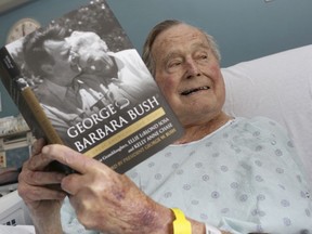 This file photo provided by Office of George H. W. Bush shows a photo of former President George H.W. Bush that was tweeted on Friday, June 1, 2018, from his hospital bed while reading a book about himself and his late wife in Biddeford, Maine. Bush is celebrating his 94th birthday in Maine. He is relaxing at his home in Kennebunkport on Tuesday, June 12, eight days after being released from the hospital where he was treated for low blood pressure.