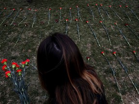 FILE - In this March 19, 2018, file photo, an activist places flowers among 5,000 flowers on the West Front of the Capitol that they said are to memorialize 5,000 children killed by Saudi bombings in Yemen on Capitol Hill in Washington. More than 10,000 children were killed or maimed amid armed conflicts worldwide last year, while others were raped, forced to serve as armed soldiers or caught in attacks on schools and hospitals, a United Nations report said Wednesday, June 27.