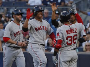 Boston Red Sox's Rafael Devers, second from left, is congratulated by teammates after hitting a grand slam against the New York Yankees during the first inning of a baseball game, Saturday, June 30, 2018, in New York.