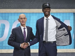 Texas' Mohamed Bamba, right, poses with NBA Commissioner Adam Silver after he was picked sixth overall by the Orlando Magic during the NBA basketball draft in New York, Thursday, June 21, 2018.