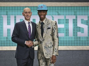 Kentucky's Shai Gilgeous-Alexander, right, poses with NBA Commissioner Adam Silver after he was picked 11th overall by the Charlotte Hornets during the NBA basketball draft in New York, Thursday, June 21, 2018.