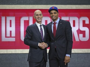Michigan State's Miles Bridges, right, poses with NBA Commissioner Adam Silver after he was picked 12th overall by the Los Angeles Clippers during the NBA basketball draft in New York, Thursday, June 21, 2018.