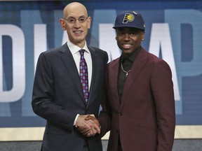 UCLA's Aaron Holiday, right, poses with NBA Commissioner Adam Silver after he was picked 23rd overall by the Indiana Pacers during the NBA basketball draft in New York, Thursday, June 21, 2018.
