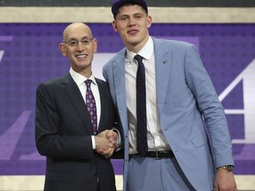 Michigan's Moritz Wagner, right, poses with NBA Commissioner Adam Silver after he was picked 25th overall by the Los Angeles Lakers during the first round of the NBA basketball draft in New York, Thursday, June 21, 2018.
