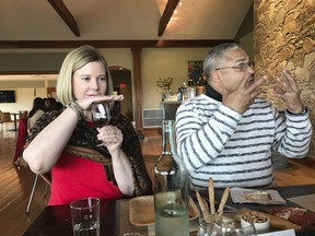 This May 19, 2018 photo shows Kim and Cliff Decatrel of Long Island demonstrating their wine-tasting technique at Macari Vineyards in Mattituck, New York, on the North Fork of Long Island.