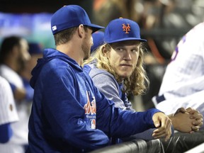 New York Mets starting pitcher Noah Syndergaard talks to a teammate during the ninth inning of the team's baseball game against the Chicago Cubs on Thursday, May 31, 2018, in New York. The Cubs won 5-1.