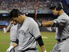 New York Yankees' Masahiro Tanaka, left, is patted on the back by teammate Aaron Judge after scoring a run on a sacrifice fly by Judge during the sixth inning of a baseball game against the New York Mets, Friday, June 8, 2018, in New York.