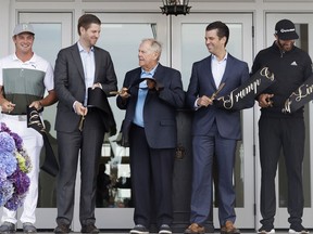 Jack Nicklaus, center, cuts the ribbon at the opening of the clubhouse at Trump Golf Links with Eric Trump, second from left, and Donald Trump, Jr., second from right, Monday, June 11, 2018, in the Bronx borough of New York. Also joining them are PGA golfers Bryson DeChambeau, left, and Dustin Johnson, right.