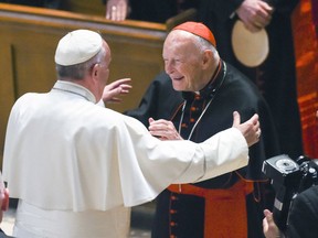FILE - In this Sept. 23, 2015 file photo, Pope Francis reaches out to hug Cardinal Archbishop emeritus Theodore McCarrick after the Midday Prayer of the Divine with more than 300 U.S. Bishops at the Cathedral of St. Matthew the Apostle in Washington. The retired archbishop of Washington, D.C. has been removed from public ministry over allegations he sexually abused a teenager while a priest in New York more than 40 years ago.