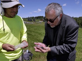 In this June 14, 2018 photo, Wade Lawrence, right, museum director and senior curator at The Museum at Bethel Woods, looks at artifacts recovered from a dig at the site of the original Woodstock Music and Art Fair, in Bethel, N.Y. Edgar Alarcon of the Public Archaeology Facility at Binghamton University looks on at left. "This is a significant historic site in American culture, one of the few peaceful events that gets commemorated from the 1960s," said Lawrence.