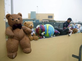 FILE - In this Saturday, June 23, 2018, file photo, a guard walks by toys placed for migrant children by protesters as they march to Homestead Temporary Shelter for Unaccompanied Children, in Homestead, Fla. Foster care advocates say the government won't likely be able to reunite thousands of children separated from parents who crossed the border illegally, and some will end up in an American foster care system that is stacked against Latinos and other minorities.