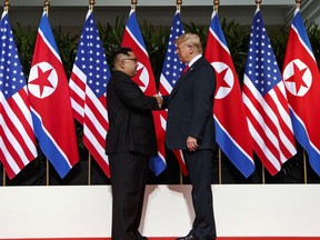 FILE - In this Tuesday, June 12, 2018, file photo, North Korean leader Kim Jong Un, left, and U.S. President Donald Trump shake hands prior to their meeting on Sentosa Island in Singapore. Trump got the history-making handshake he wanted with Kim. Now that the snapshot is a part of history, new details are emerging about the behind-the-scenes negotiations that led up to the summit.