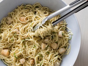 This undated photo provided by America's Test Kitchen in May 2018 shows spaghetti with lemon, basil and scallops in Brookline, Mass. This recipe appears in the cookbook "Cooking At Home With Bridget And Julia."
