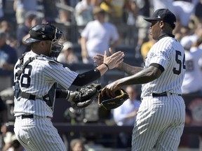 New York Yankees closer Aroldis Chapman (54) celebrates with catcher Austin Romine (28) after Chapman got the save after the Yankees defeated the Seattle Mariners 4-3 in a baseball game Thursday, June 21, 2018, at Yankee Stadium in New York.