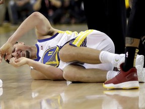 Golden State Warriors guard Klay Thompson remains on the floor during the first half of Game 1 of basketball's NBA Finals between the Warriors and the Cleveland Cavaliers in Oakland, Calif., Thursday, May 31, 2018.