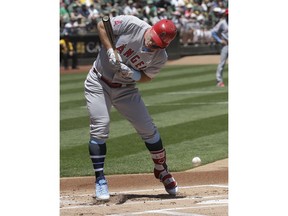 Los Angeles Angels' Mike Trout is hit by a throw from Oakland Athletics pitcher Daniel Mengden during the first inning of a baseball game in Oakland, Calif., Sunday, June 17, 2018.