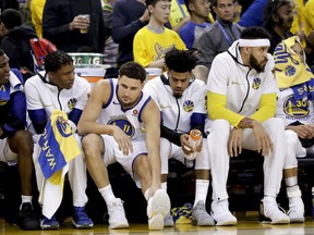 Golden State Warriors guard Klay Thompson (11) sits on the bench with teammates during the first half of Game 1 of basketball's NBA Finals against the Cleveland Cavaliers in Oakland, Calif., Thursday, May 31, 2018.