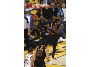 Cleveland Cavaliers forward LeBron James (23) dunks against the Golden State Warriors during the second half of Game 1 of basketball's NBA Finals in Oakland, Calif., Thursday, May 31, 2018.