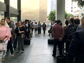 In this Tuesday, June 19, 2018 photo, immigrants awaiting deportation hearings, line up outside the building that houses the immigration courts in Los Angeles. Inside the courtroom, immigrant children who arrived on the U.S. border seeking asylum or other relief attended a special hearing for juveniles on the status of their cases.