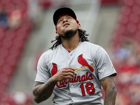 St. Louis Cardinals starting pitcher Carlos Martinez reacts as he walks towards the dugout after closing the second inning of a baseball game against the Cincinnati Reds, Sunday, June 10, 2018, in Cincinnati.