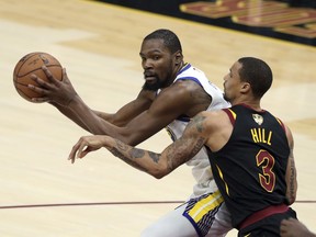 Golden State Warriors' Kevin Durant is defended by Cleveland Cavaliers' George Hill during the second half of Game 3 of basketball's NBA Finals, Wednesday, June 6, 2018, in Cleveland.