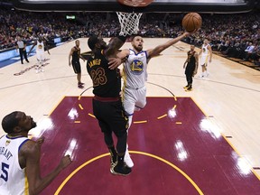 Golden State Warriors guard Stephen Curry (30 shoots around Cleveland Cavaliers forward LeBron James (23) in Game 4 of basketball's NBA Finals on Friday, June 8, 2018, in Cleveland. The Warriors defeated the Cavaliers 108-85 to sweep the series.