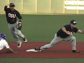 Oregon State shortstop Cadyn Grenier catches a ball to double off LSU's Jake Slaughter while Nick Madrigal celebrates during an NCAA college baseball tournament regional game in Corvallis, Ore., Saturday, June 2, 2018.