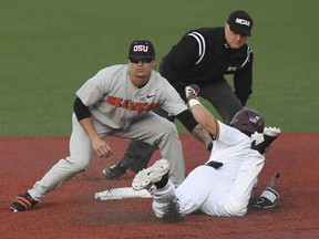 Oregon State shortstop Cadyn Grenier (2) tags out Minnesota's Ben Mezzenga (1) during an NCAA college baseball tournament super regional game Saturday, June 9, in Corvallis, Ore.