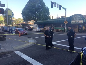 Police stand outside across from The Cheerful Tortoise bar at the scene of an earlier shooting in Portland, Ore., Friday, June 29, 2018. Portland State University police shot and killed a man while responding to bar fight near campus, and a witness said the victim had been trying to stop the melee early Friday.