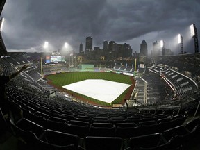 A young baseball fan in the last row of the upper deck at PNC Park waits out a downpour during a delay of the start of a baseball game between the Pittsburgh Pirates and the Milwaukee Brewers in Pittsburgh, Wednesday, June 20, 2018.