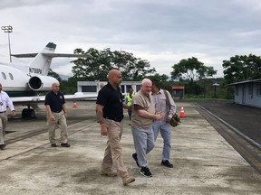 In this photo released by Panama's Security Ministry, former Panamanian President Ricardo Martinelli is escorted by a U.S. Marshall upon his arrival to the Tocumen International Airport in Panama City, Monday, June 11, 2018. Martinelli returned to Panama to face political espionage and embezzlement charges after being extradited from the United States on Monday. (Panama's Security Ministry via AP)