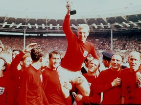 FILE - In this July 30 1966 file photo, England's soccer captain Bobby Moore, carried shoulder high by his teammates, holds aloft the Jules Rimet Trophy. England defeated Germany 4-2 in the final of the 1966 World Cup at London's Wembley Stadium. The 21st World Cup begins on Thursday, June 14, 2018, when host Russia takes on Saudi Arabia. (AP Photo, File)
