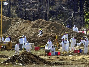 FILE – In this Sept. 16, 2001, file photo, FBI investigators continue excavating the crash site of United Flight 93 in Shanksville, Pa. Officials announced Friday, June 1, 2018, that later in the year, the National Park Service will return the remaining wreckage of United Flight 93 to the Pennsylvania memorial marking where it crashed in the 9/11 terror attacks, and the remaining wreckage will be buried in a restricted area accessible only to loved ones of the victims.