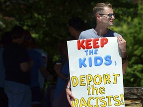 FILE - In this June 15, 2018 file photo, Chris Olson, of Lake Wallenpaupack, Pa., holds a sign outside Lackawanna College where U.S. Attorney Jeff Sessions spoke on immigration policy and law enforcement actions, in Scranton, Pa. The Trump administration's move to separate immigrant parents from their children on the U.S.-Mexico border has turned into a full-blown crisis in recent weeks, drawing denunciation from the United Nations, Roman Catholic bishops and countless humanitarian groups.