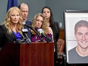 FILE – In this May 5, 2017, file photo, Centre County, Pa., District Attorney Stacy Parks Miller, left, announces findings in an investigation into the death of Penn State University fraternity pledge Tim Piazza, seen in photo at right, as his parents, Jim and Evelyn Piazza, second and third from left, stand nearby during a news conference in Bellefonte, Pa. A judge is refusing to reinstate involuntary manslaughter charges against five former Penn State fraternity members arrested in the pledge's hazing-related death last year. Prosecutors tried appealing a magistrate's decision to dismiss the most serious charges in the death of Piazza of Lebanon, New Jersey. Piazza died of severe head and abdominal injuries after falling several times at the house the night of a bid acceptance ceremony and party.