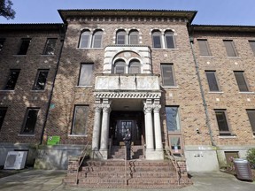 FILE - In this file photo taken April 11, 2017, a security officer stands on steps at the entrance to Western State Hospital, in Lakewood, Wash. Washington state's largest psychiatric hospital has lost its federal certification and $53 million in federal funds after failing to achieve basic health and safety standards.