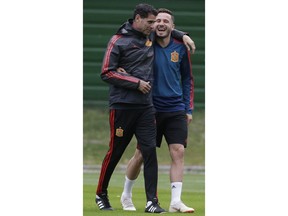 Spain head coach Fernando Hierro, left, smiles with Spain's Saul, right, during the official training on the eve of the group B match between Morocco and Spain at the Mirny stadium in Kaliningrad, Russia, Sunday, June 24, 2018.