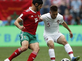 Morocco's Noureddine Amrabat, left, challenges for the ball Portugal's Raphael Guerreiro, right, during the group B match between Portugal and Morocco at the 2018 soccer World Cup in the Luzhniki Stadium in Moscow, Russia, Wednesday, June 20, 2018.