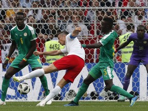 Poland's Robert Lewandowski, 2n left, takes a shot during the group H match between Poland and Senegal at the 2018 soccer World Cup in the Spartak Stadium in Moscow, Russia, Tuesday, June 19, 2018.